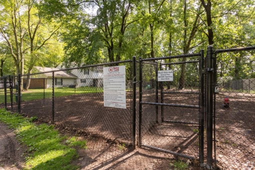 a fence with a sign on it in front of a dog park