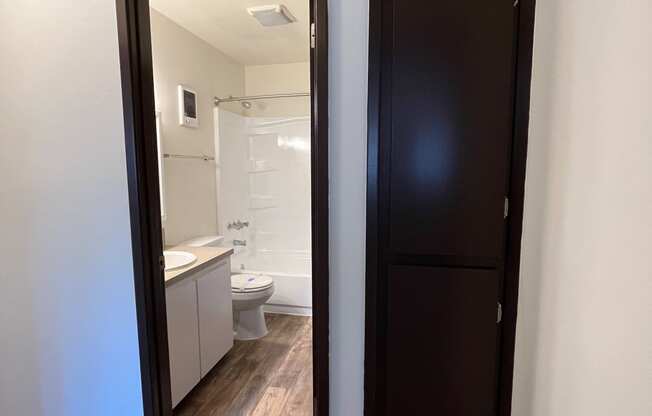 an open door leading into a bathroom with a toilet and sink