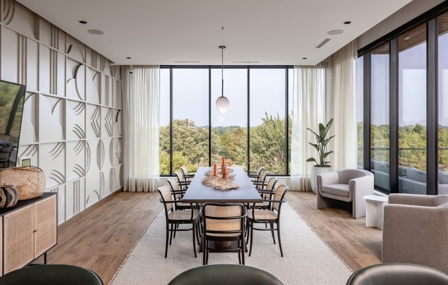 a dining room with a long dining table and a large window