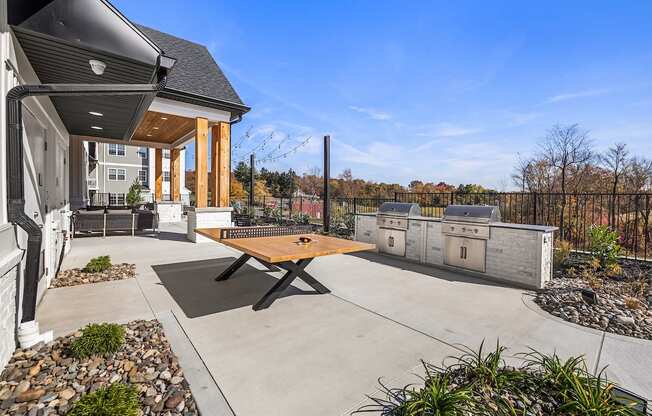 A modern house with a wooden table in the backyard.