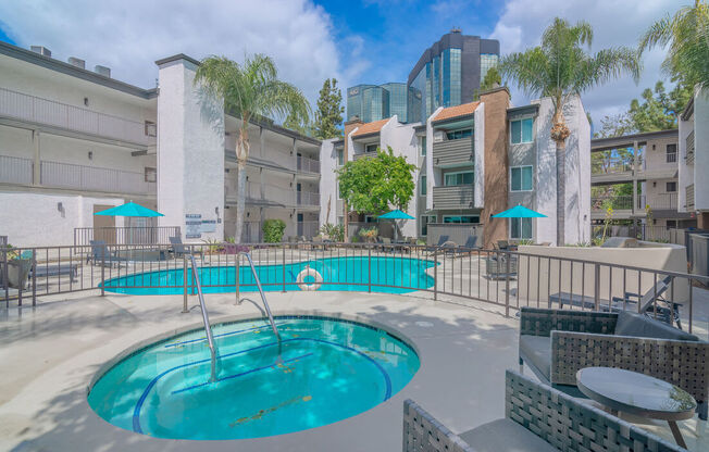 a swimming pool at a hotel with palm trees at City View Apartments at Warner Center, California, 91367