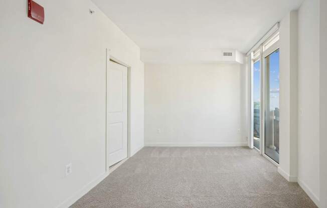 A room with a carpet floor and a door.