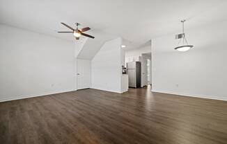 a bedroom with hardwood floors and white walls