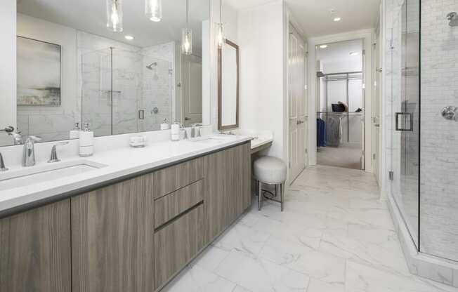 a bathroom with a large vanity with two sinks and a walk in shower
