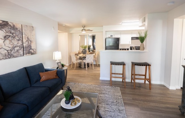 a living room and kitchen with a blue couch and a coffee table