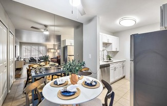 an open kitchen and dining room with a table and chairs at Town & Country Apartments - Wixom, MI, Wixom, Michigan