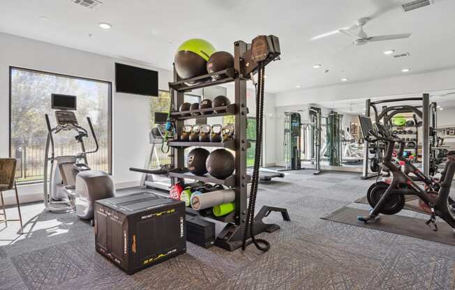 a gym with weights and cardio equipment in a building with a window