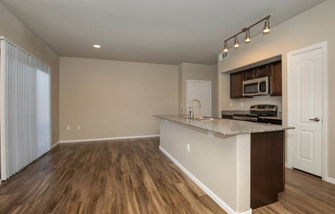 wooden cabinets and appliances in kitchen and dining areaat The Cantera by Picerne, Las Vegas, NV