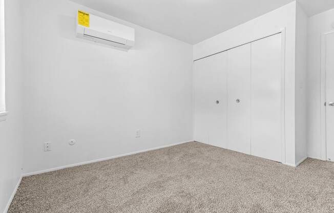 a bedroom with white walls and carpet