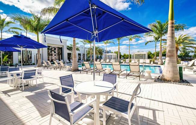 a patio with tables and chairs and umbrellas next to a pool at Altis Santa Barbara, Naples
