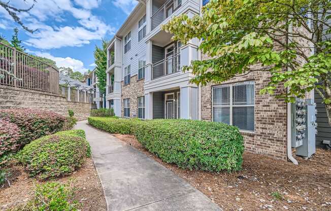 an apartment building with a sidewalk in front of it