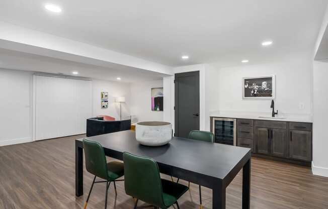 a dining area with a table and chairs and a kitchen in the background