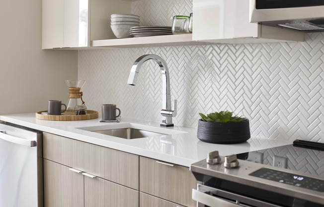 Immerse yourself in modern elegance with Modera Clarendon's two-tone 42” cabinetry and chic subway tile backsplash, adding flair to your kitchen space.