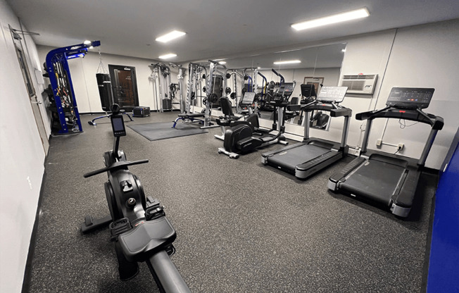 a spacious fitness center with treadmills and other exercise equipment