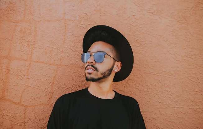 Man Wearing Sunglasses Against Orange Wall