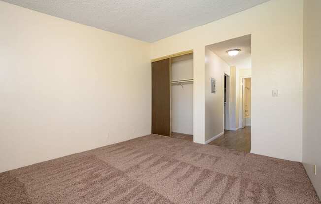 a bedroom with a carpeted floor and white walls at Park Columbia Apts, Hemet