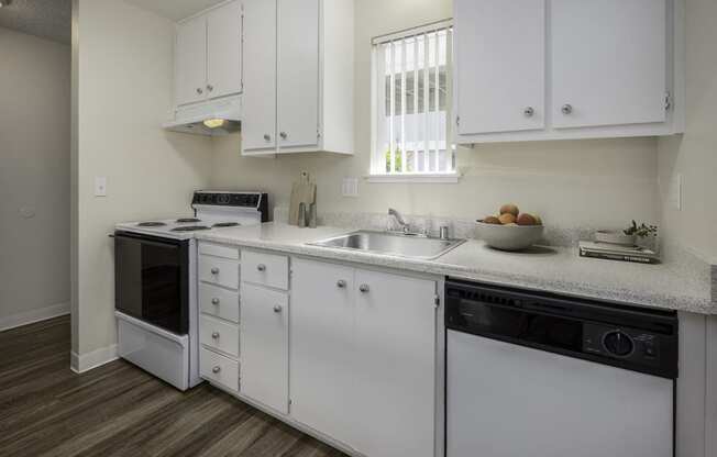 a kitchen with white cabinets and a sink and a dishwasher