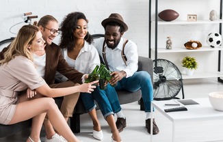 Four people sitting on a couch in a living room at Portofino Vineyards Apartment, Florida