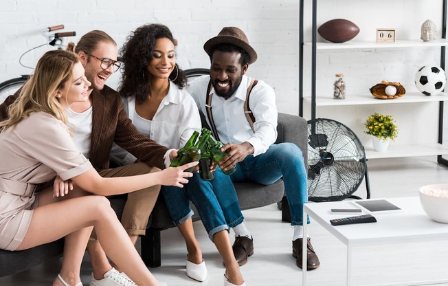Four people sitting on a couch in a living room at Portofino Vineyards Apartment, Florida