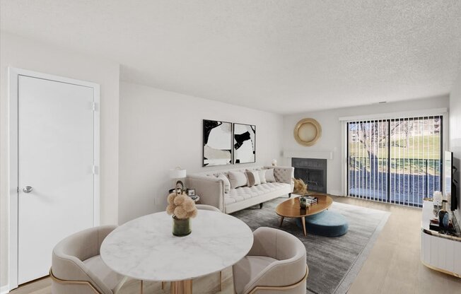 A living room with a white couch, a coffee table, and a large window.