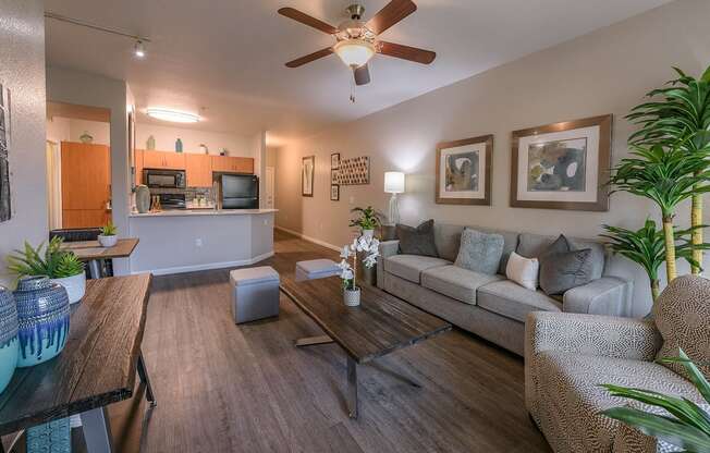 A living room with a couch, coffee table, and a ceiling fan.