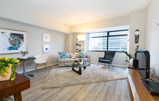 a living room with a couch and a table and a window at Apartments at Denver Place, Denver, 80202