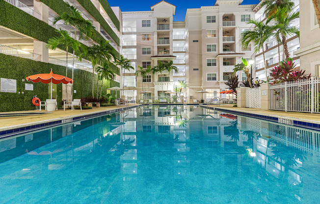 A large indoor swimming pool with a green wall on the side.