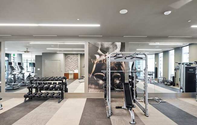 A gym with a variety of equipment including weights and cardio machines.