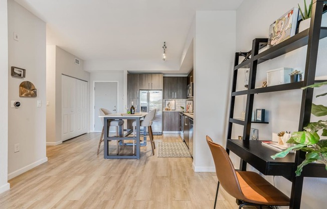 a living room with a dining room and a kitchen with a table and chairs