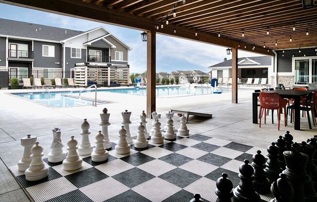 A giant chess set is set up on a checkered floor.