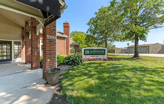 The entrance to a building with a sign that says "Fair Silverwood Apartments".