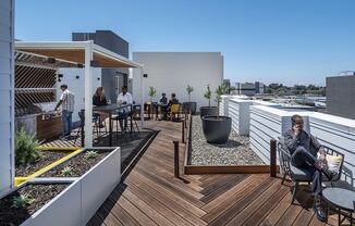 a view of the rooftop terrace with people eating and drinking on a sunny day