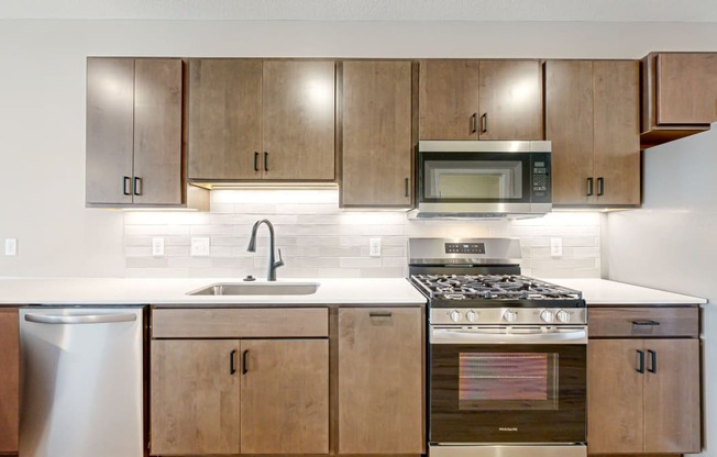 a kitchen with wooden cabinets and stainless steel appliances