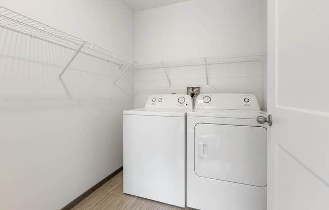 A white washing machine and dryer in a small laundry room.
