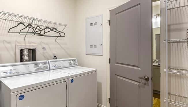 a washer and dryer in a laundry room with a door to the bathroom