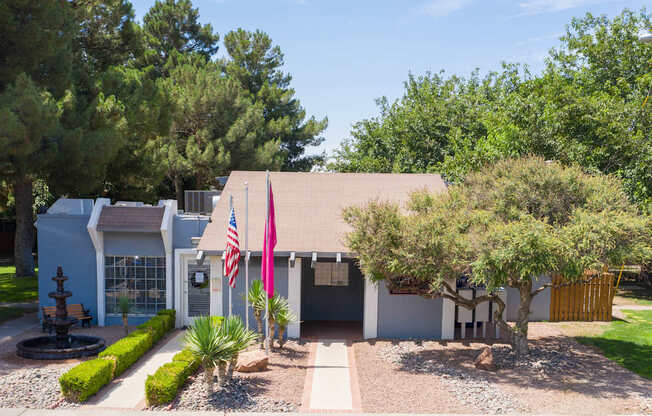 A house with a flag and a tree in front.