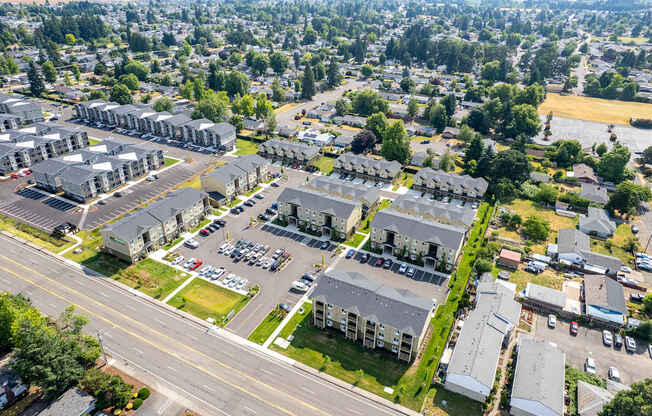 A bird's eye view of a residential area with multiple houses and parked cars.