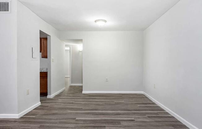 an empty living room with white walls and wood floors