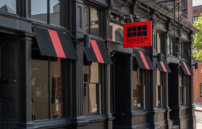 A black building with a red sign that says DENDEN.