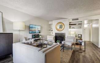 A living room with a fireplace and a painting on the wall.