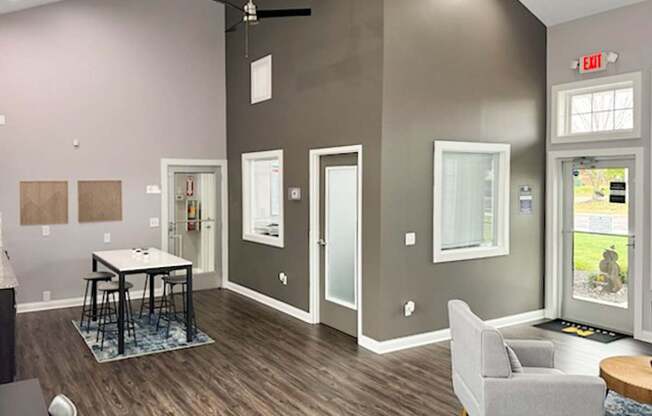 a living room with gray walls and a table and chairs