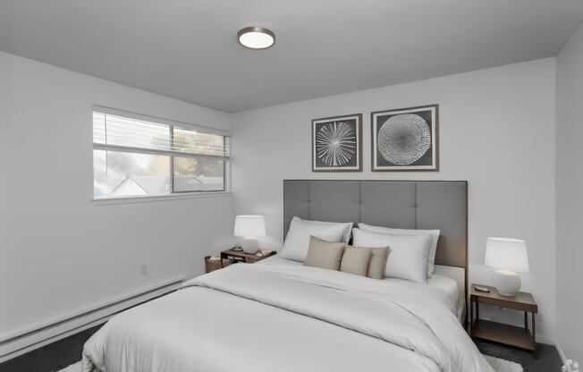 bedroom with white walls and a white bed with white sheets and pillows