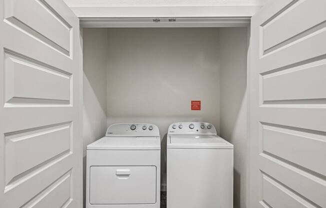 A white laundry room with a washer and dryer.