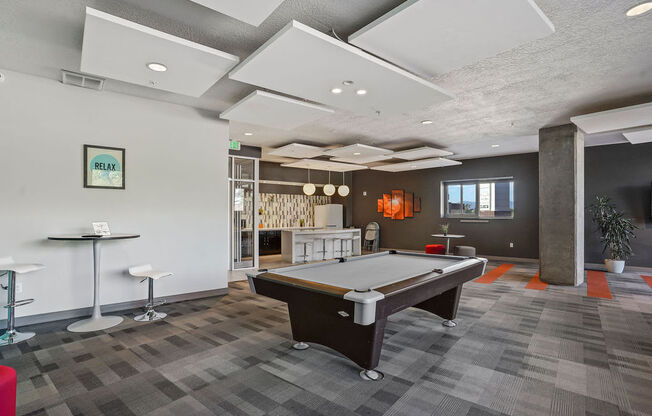 a games room with a pool table and bar