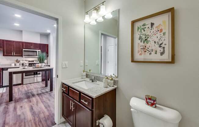 a bathroom with a sink, toilet, and mirror