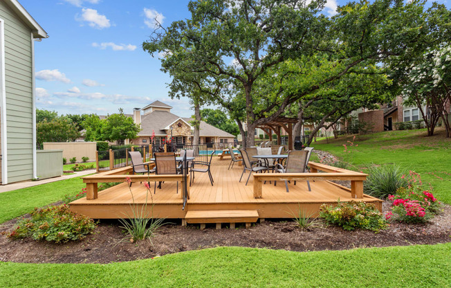 a wooden deck with a table and chairs on it