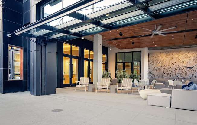 A modern outdoor seating area with white furniture and a wooden ceiling.