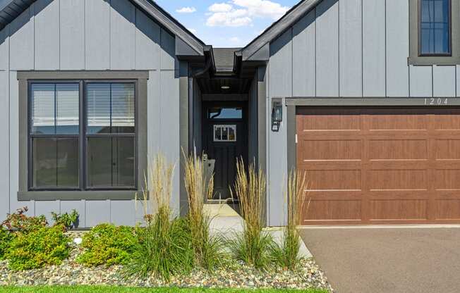 the front of a house with a garage door and