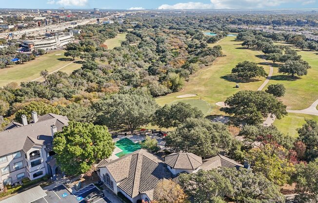 A bird's eye view of a residential area with houses and a swimming pool.
