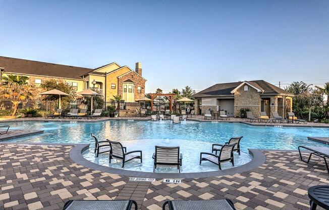 a large swimming pool with patio furniture in front of a house at Waterstone at Cinco Ranch, Katy